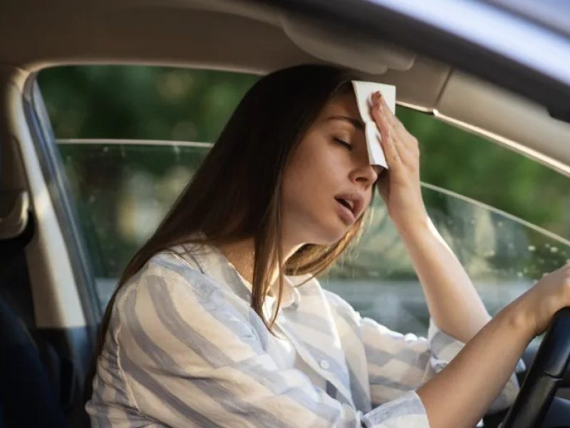 pessoa dirigindo e suando no carro